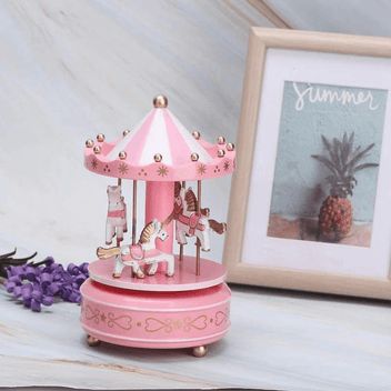 Boîte à musique carrousel rose de 18 cm, avec 4 chevaux blancs et marron sous un toit rayé rose et blanc.