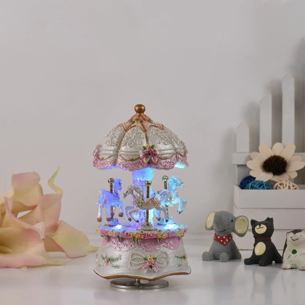 Boîte à musique carrousel blanc en résine avec 3 chevaux, des ornements roses et des lumières LED.