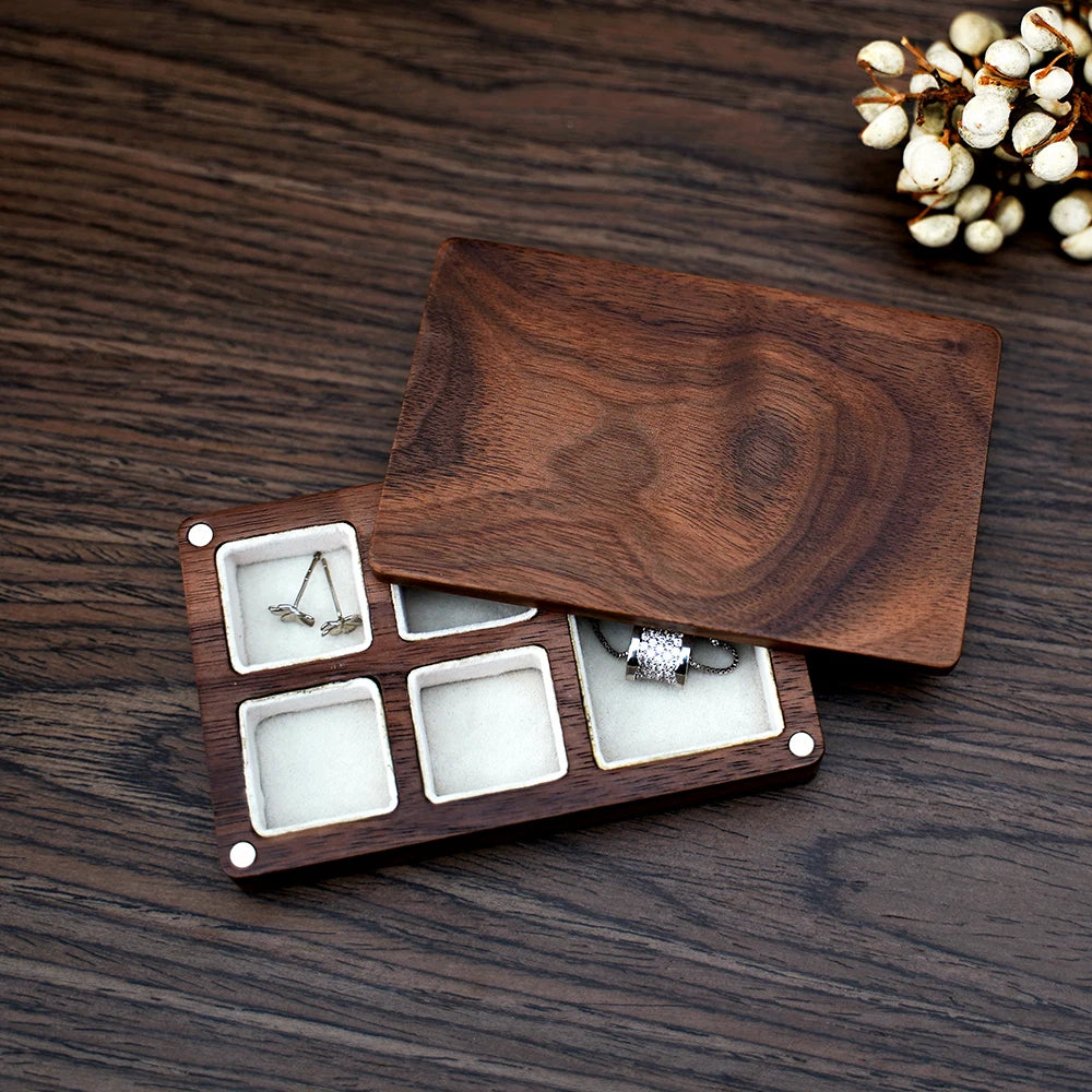 Boîte à bijoux rectangulaire en bois brun foncé avec couvercle légèrement ouvert. L'intérieur est divisé en six compartiments