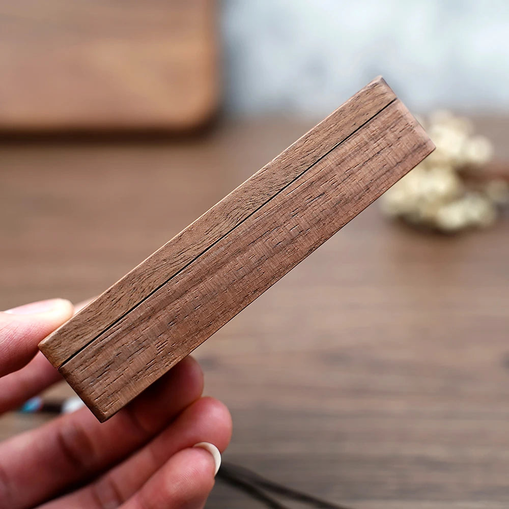 Vue rapprochée d'une boîte à bijoux rectangulaire en bois brun, tenue dans une main. Boîte à Bijoux en Bois avec Présentoir