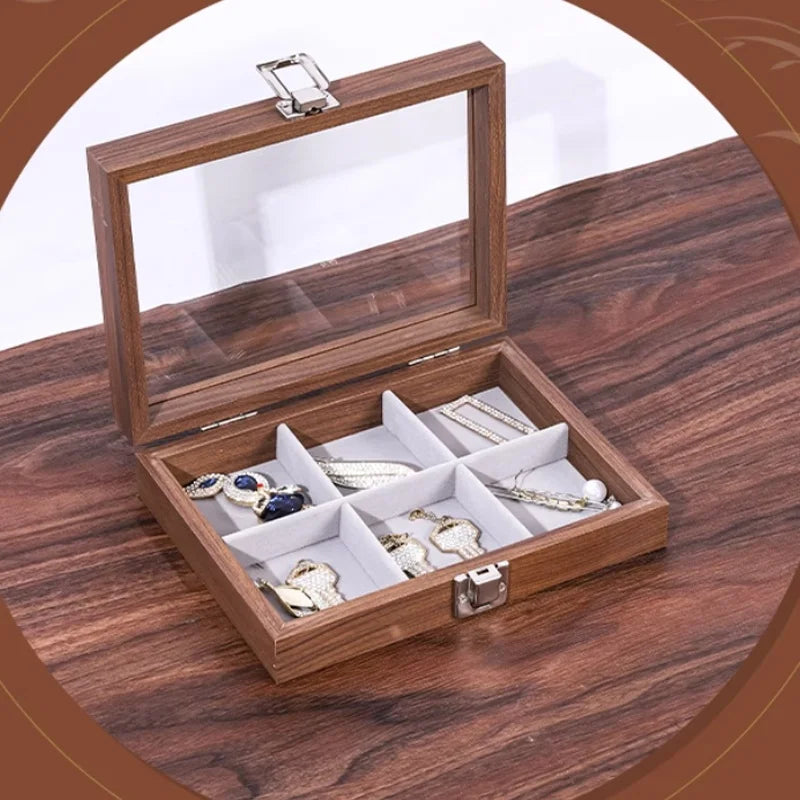 Boîte à bijoux rectangulaire en bois de noyer marron avec couvercle en verre ouvert et intérieur gris compartimenté contenant