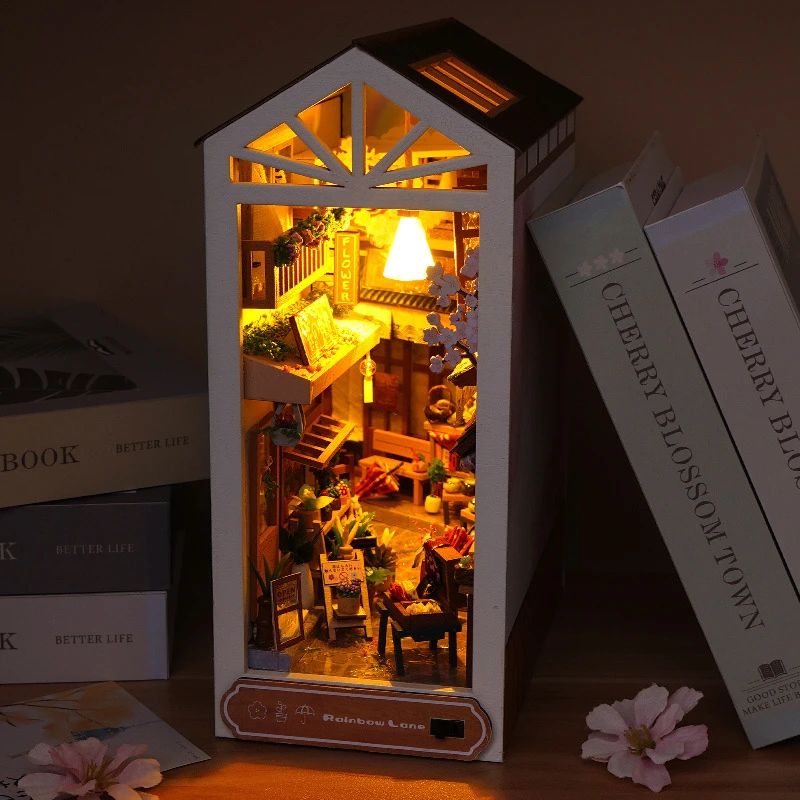 Serre-livres en bois blanc avec lumières LED. Il représente une rue japonaise miniature détaillée, avec fleurs de cerisier.