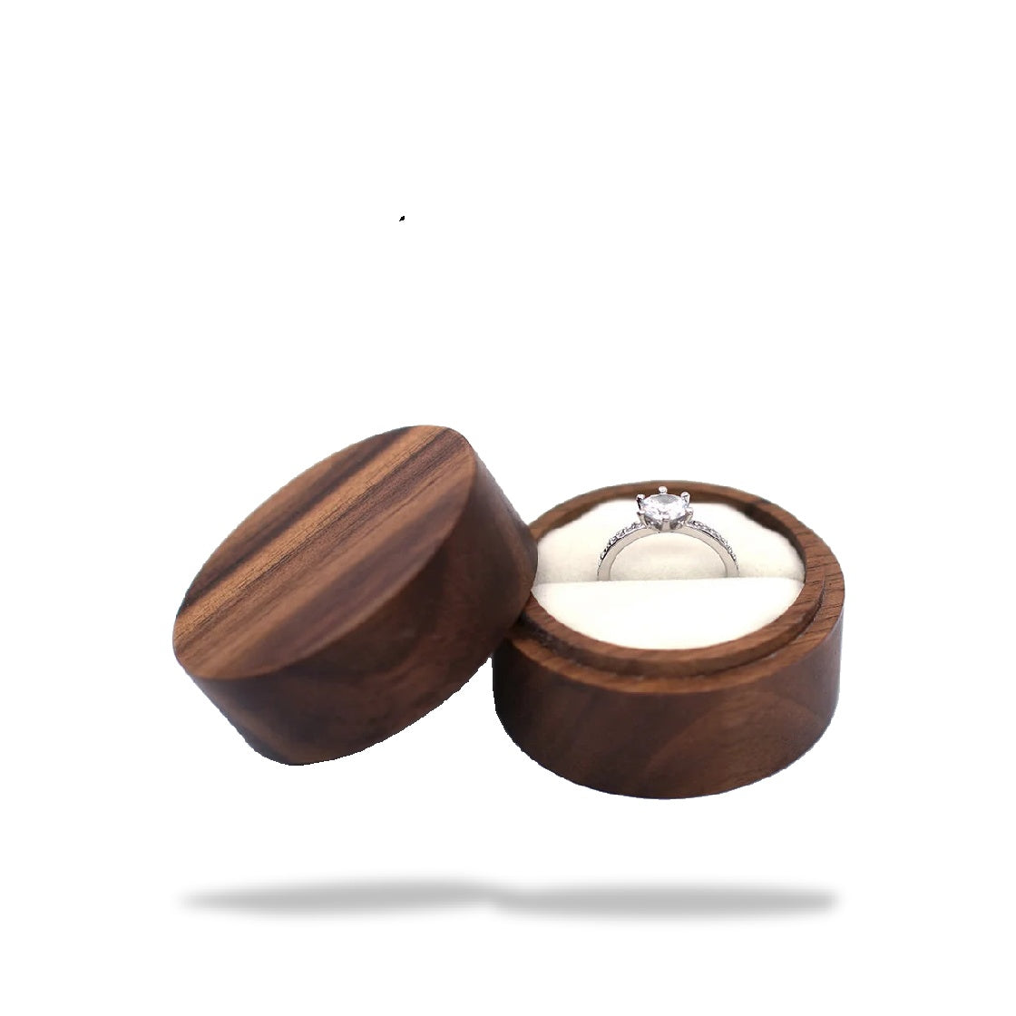 Boîte à bague de fiançailles ronde en bois sombre, ouverte avec un anneau argenté serti d'une pierre dans un écrin de tissu b