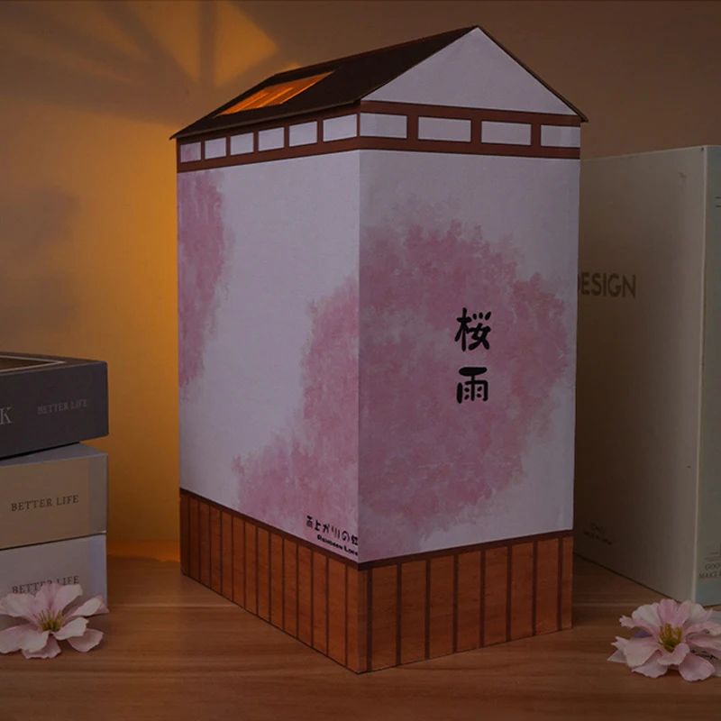 Kit de serre-livres en forme de maison japonaise traditionnelle, avec murs roses et base en bois.
