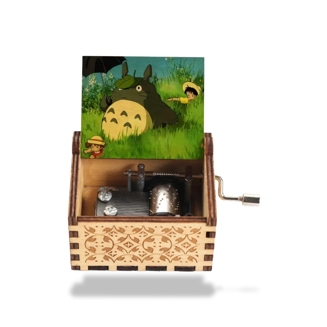 Boîte à musique en bois clair avec Totoro sous un parapluie et deux enfants, motifs gravés et mécanisme visible.