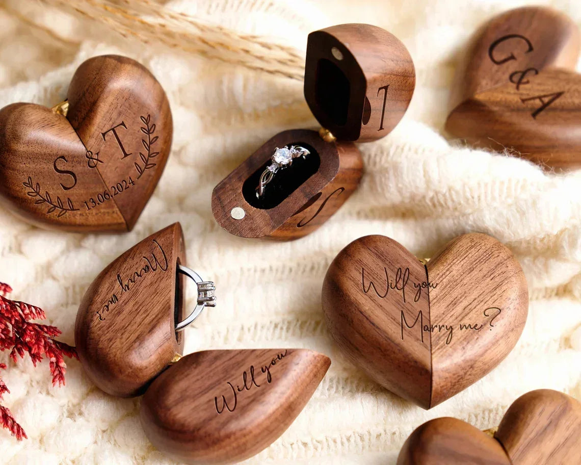 Boîtes à bague en bois de noyer en forme de cœur, ouvertes et fermées, certaines avec une gravure personnalisée.