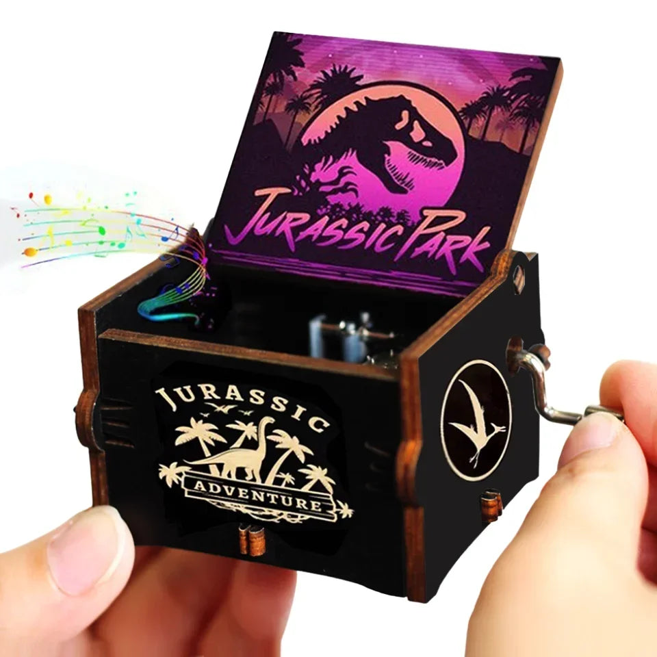 Boîte à musique noire en bois ouverte avec couvercle illustré Jurassic Park. Vue de face avec manivelle.