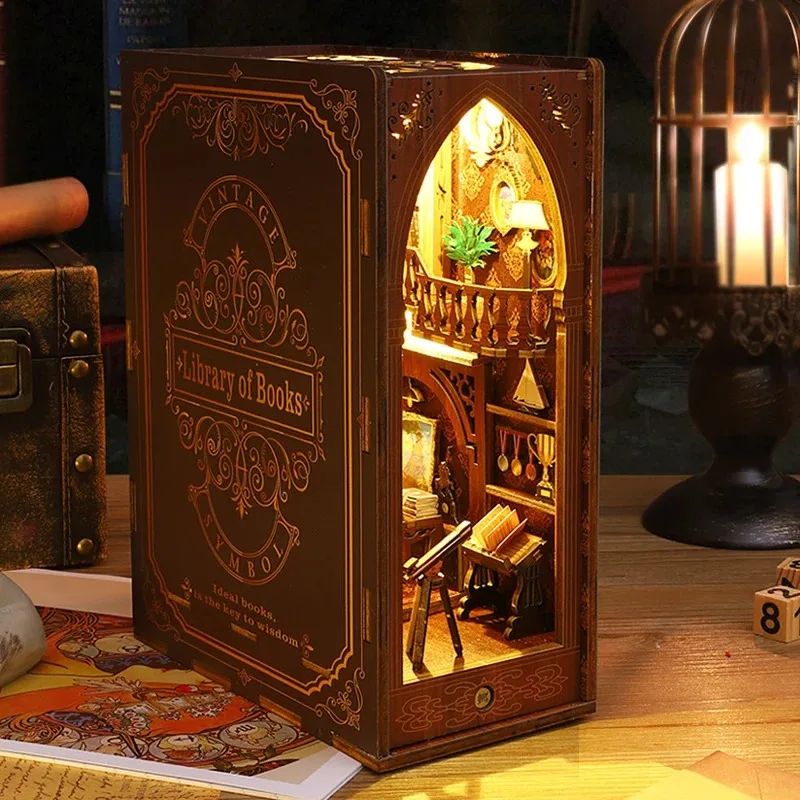 Book nook en bois marron foncé avec inscription 'Library of Books', éclairé par des LED, montrant une bibliothèque miniature.
