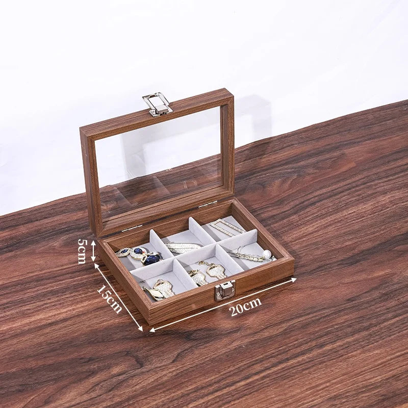 Boîte à bijoux ouverte en bois de noyer avec couvercle en verre, divisée en six compartiments de rangement. Dimensions indiqu
