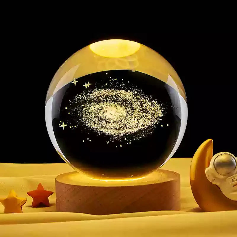Veilleuse LED avec sphère en verre transparent sur socle en bois, projetant une galaxie lumineuse.
