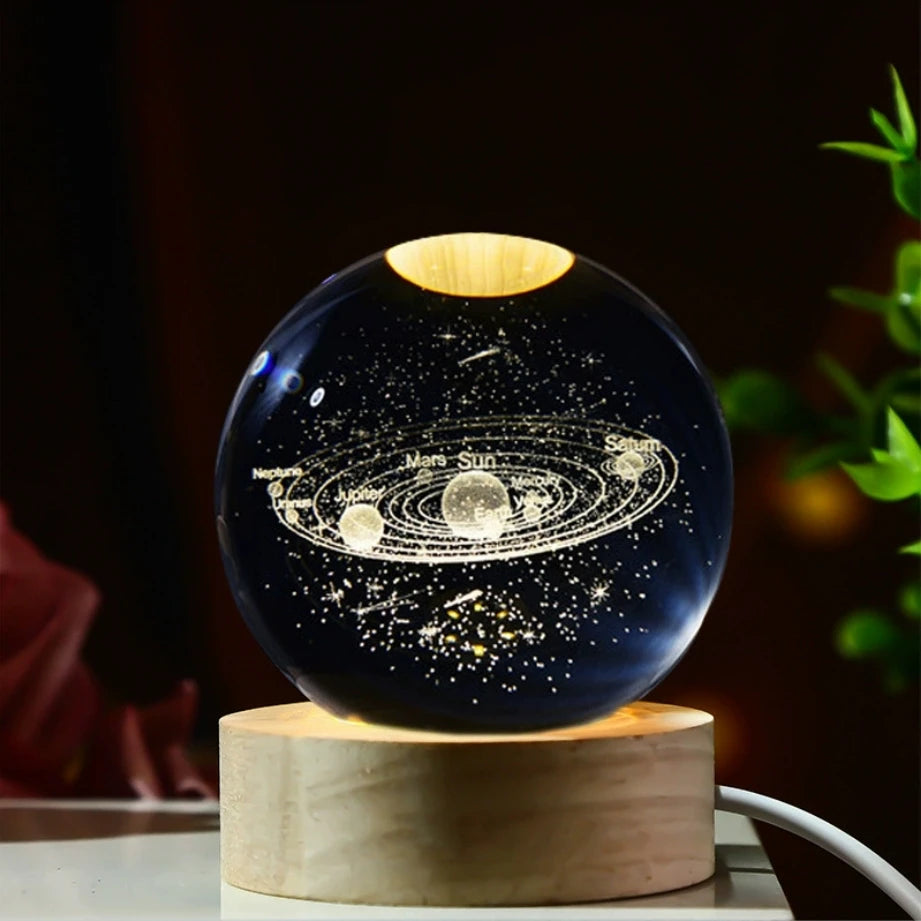 Veilleuse LED avec une sphère en verre affichant le système solaire illuminé, posée sur une base en bois.