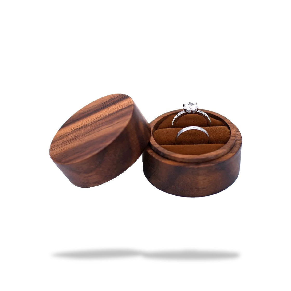 Boîte à bague de fiançailles ronde en bois sombre, ouverte. L'intérieur en tissu brun abrite deux bagues en argent.