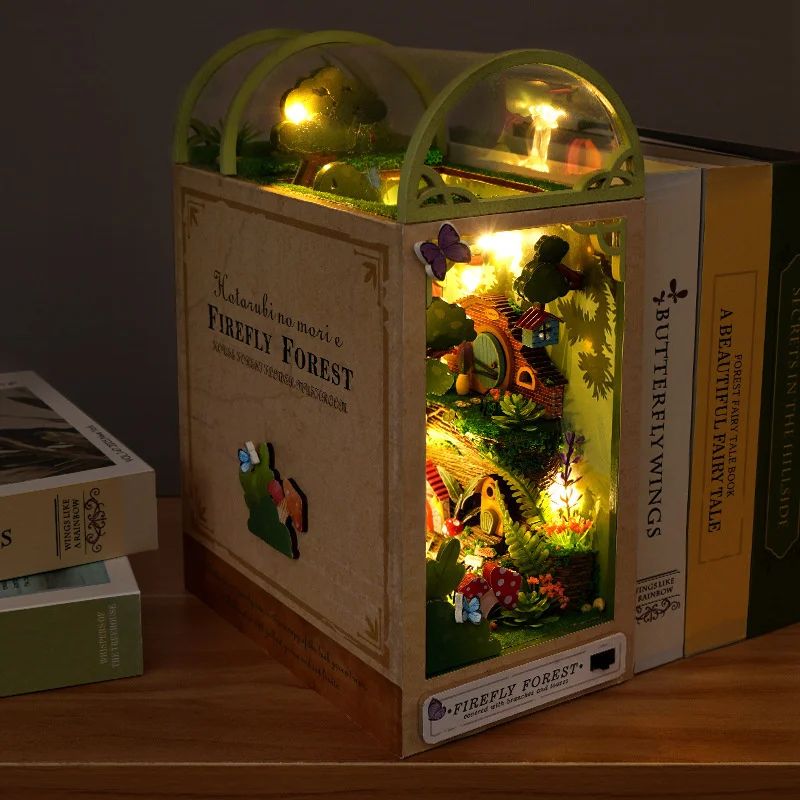Serre-livres en bois Book Nook avec lumières LED. Il représente une forêt miniature et une maison de Hobbit.