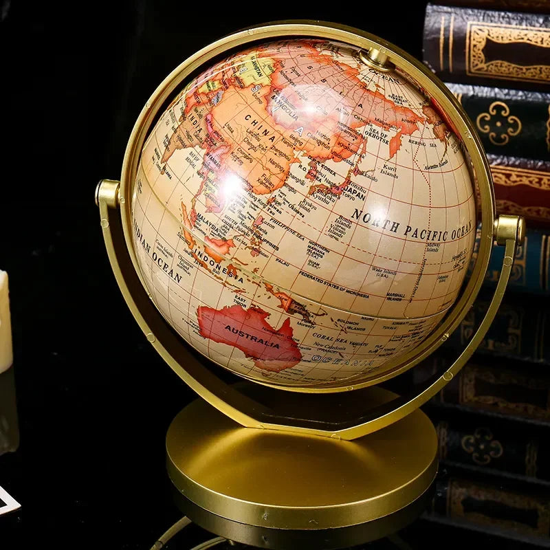 Globe terrestre décoratif avec carte du monde aux tons chauds, monté sur un support doré en métal.