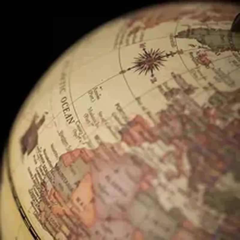 Vue rapprochée d'un globe terrestre rétro avec une carte détaillée des continents et un texte lisible sur les océans.