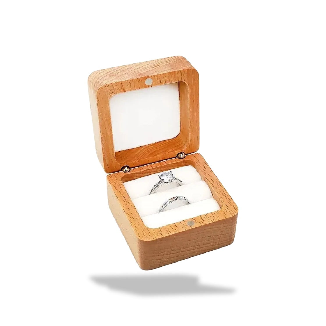 Boîte à bagues carrée en bois clair ouverte, contenant un anneau et une bague de fiançailles avec pierre.