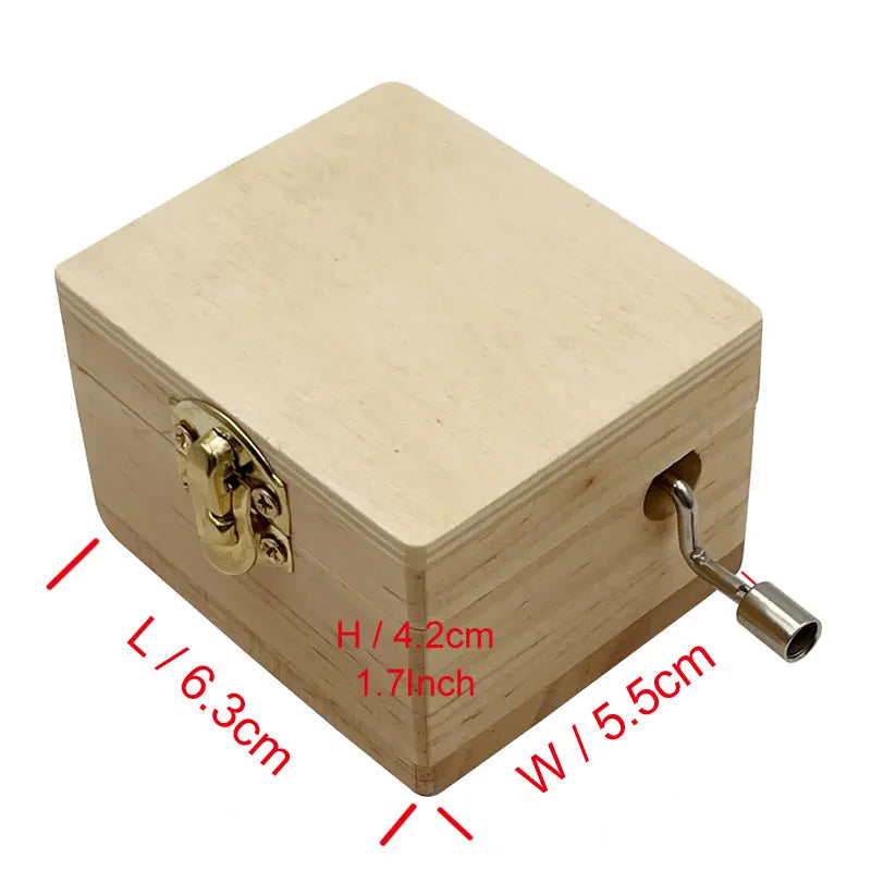 Boîte à musique rectangulaire en bois clair avec fermoir doré et manivelle sur le côté. Détails de taille.
