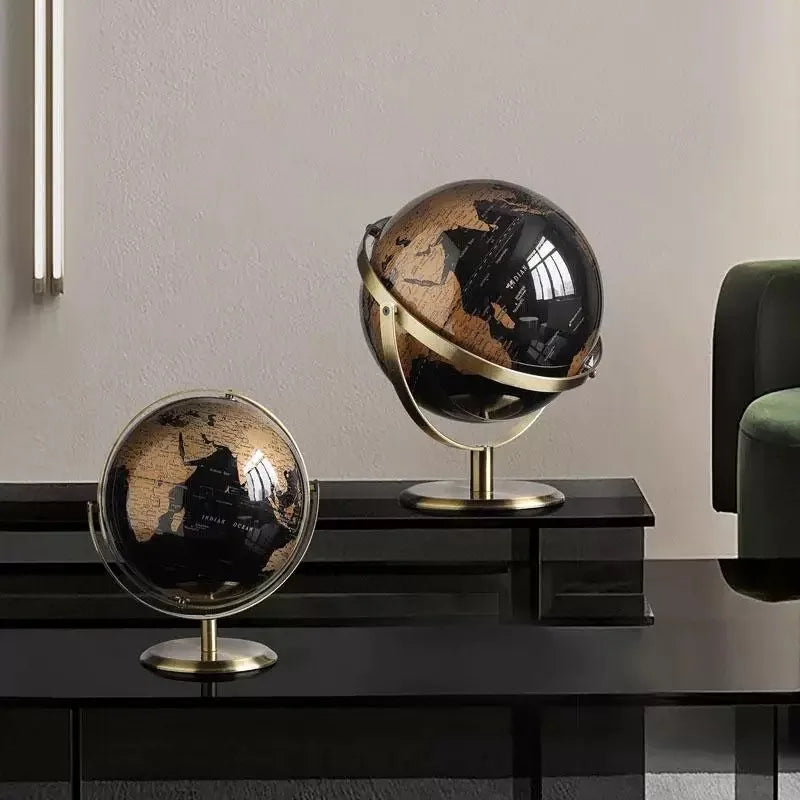 Deux globes terrestres de bureau en plastique, carte noire et dorée sur socle métallique. Un est plus grand et rotatif.