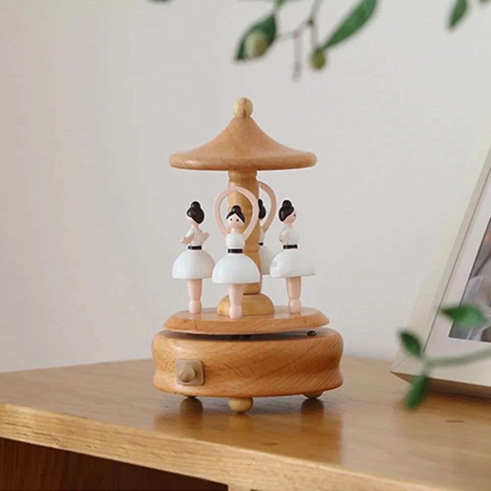 Boîte à musique en bois de hêtre naturel avec quatre danseuses miniatures en tutu blanc qui tournent.