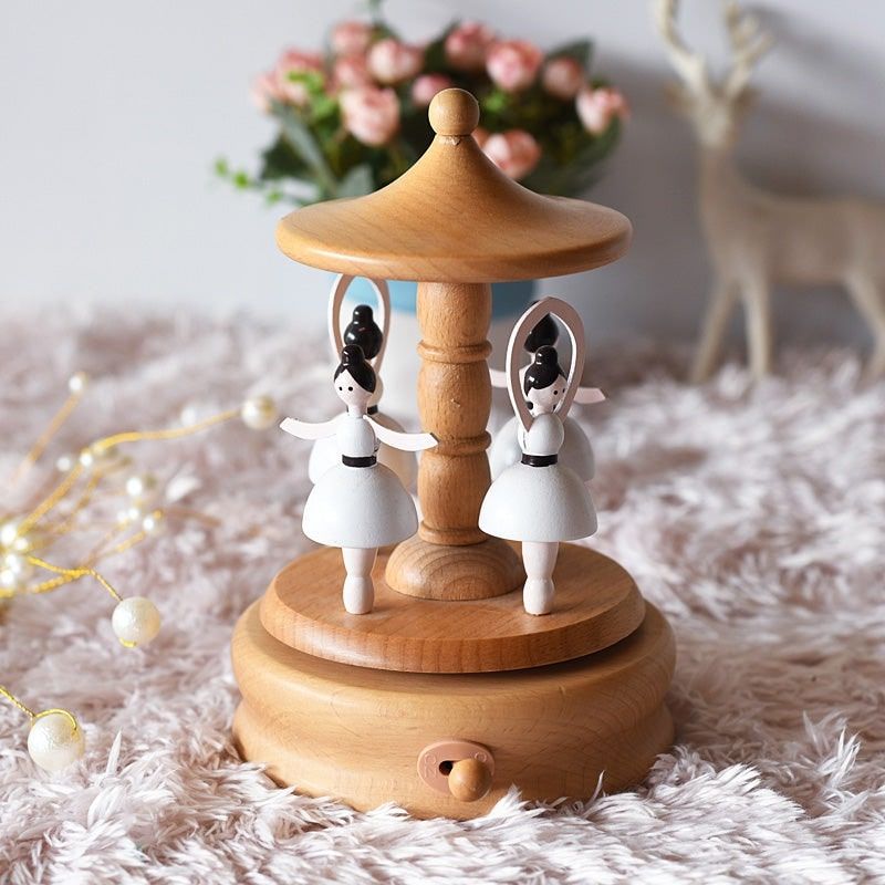 Boîte à musique en bois de hêtre, avec deux figurines de danseuses en robe blanche sur une plateforme rotative. La base est é