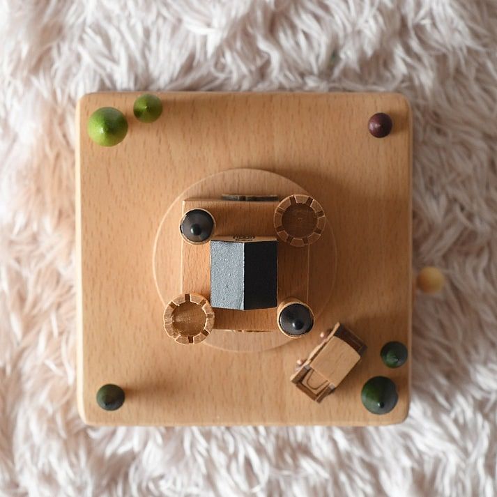 Boîte à musique en bois de hêtre représentant un château avec des remparts, des tours et une voiture miniature.