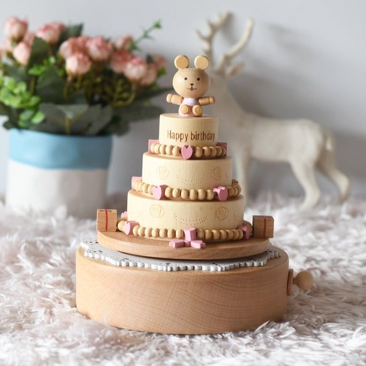 Boîte à musique en hêtre en forme de gâteau d'anniversaire à trois étages avec figurine ourson sur le dessus.