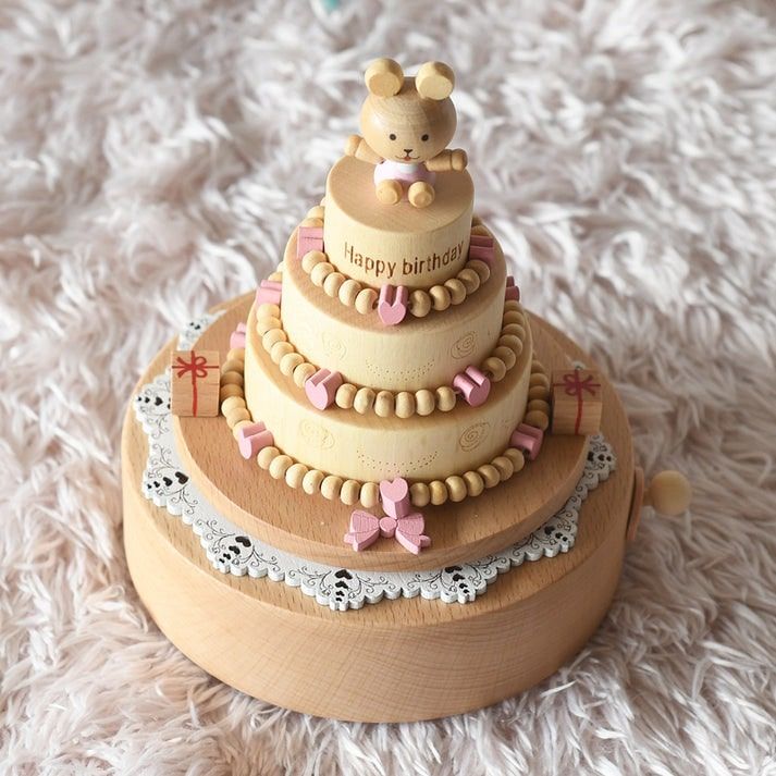 Boîte à musique en bois clair en forme de gâteau d'anniversaire à trois étages avec figurine d'ours, détails roses et gravure