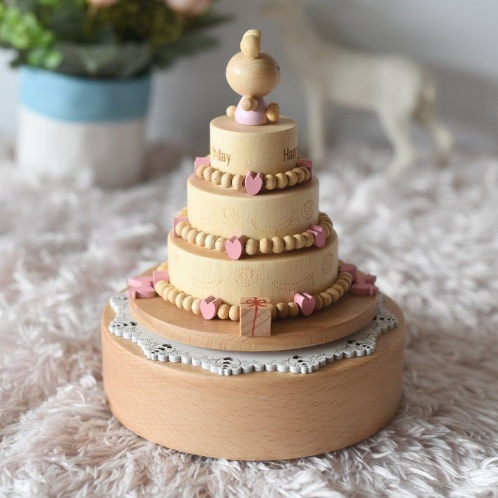 Boîte à musique en bois de hêtre en forme de gâteau d'anniversaire à trois étages, décorée de cœurs roses et surmontée d'un l
