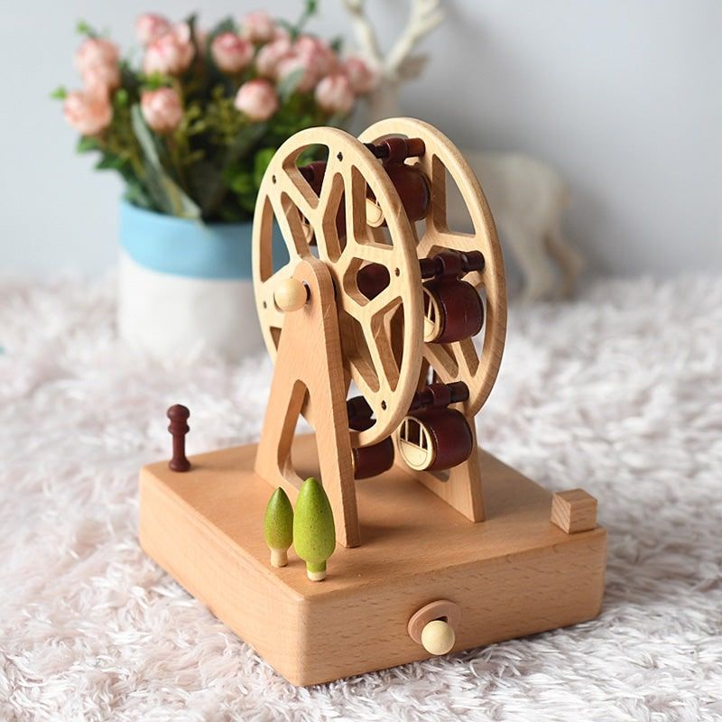 Boîte à musique en bois de hêtre sculpté représentant une grande roue avec des nacelles, mesurant 17,3 cm.