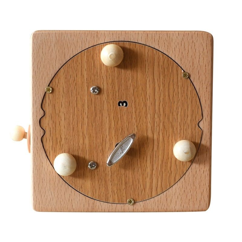 Boîte à musique carrée en hêtre, face avant vue de dessus. Elle présente un disque central en bois plus clair avec une manive