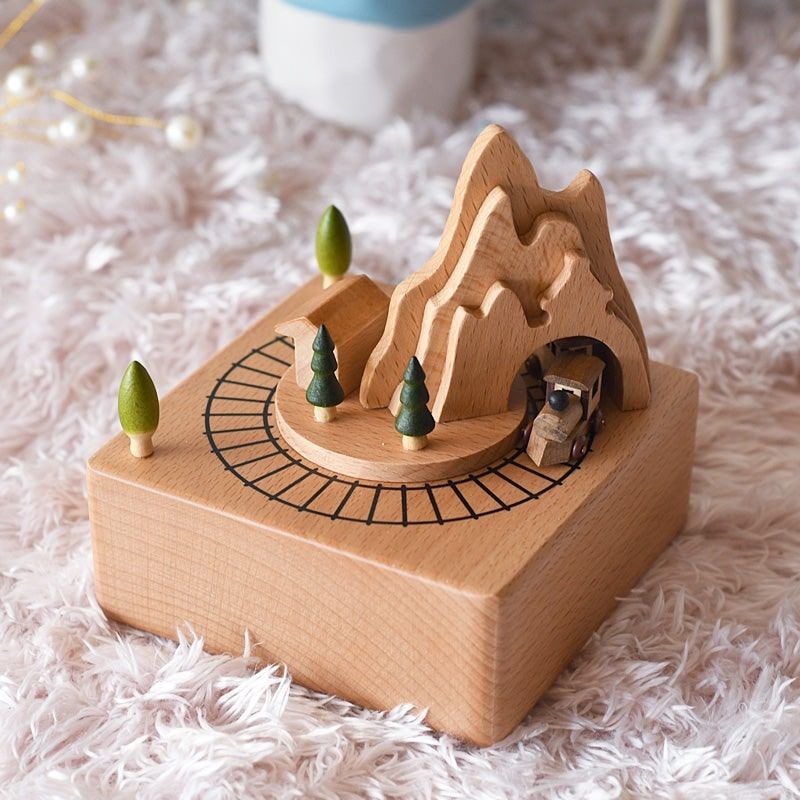 Boîte à musique en bois de hêtre avec décor montagne et tunnel, un train en bois et des arbres miniatures.