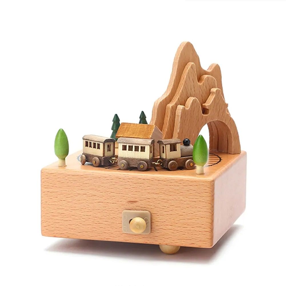 Boîte à musique en hêtre avec un train miniatures circulant près de montagnes sculptées et des arbres.