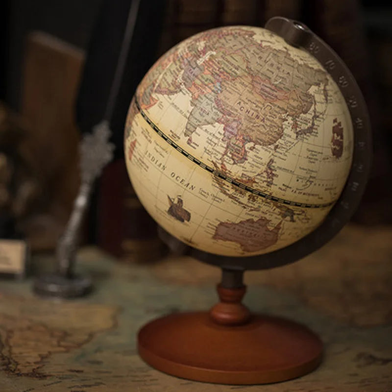 Globe terrestre rétro d'une hauteur de 22 cm avec une sphère de 14 cm de diamètre sur une base en bois.