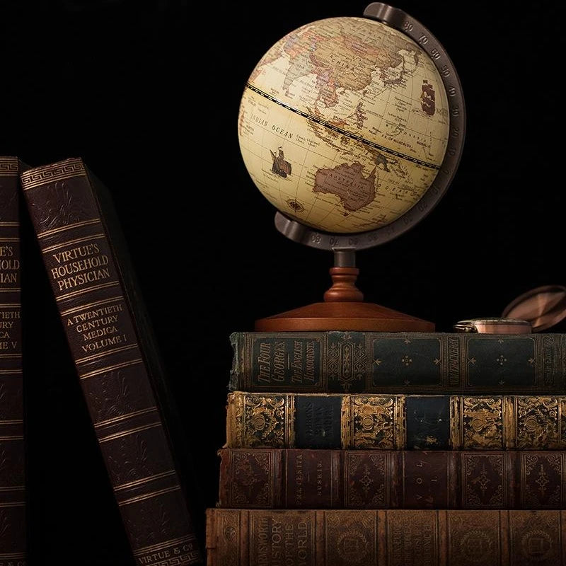 Globe terrestre rétro avec carte vieillie, monté sur un support métallique gradué et une base en bois.