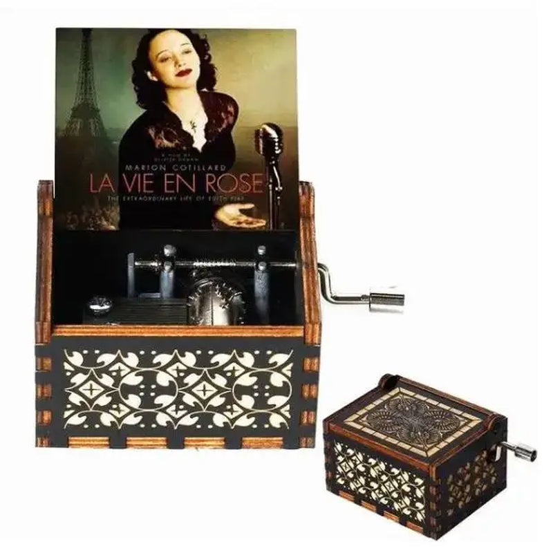 Boîte à musique en bois marron et noir avec motifs découpés. Un poster de film avec Marion Cotillard est visible.