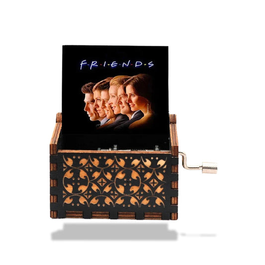 Boîte à musique Friends en bois noir, motifs ajourés, avec manivelle et poster du casting de la série.
