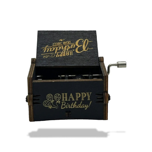 Boîte à musique en bois noir, ouverte, avec manivelle métallique et inscriptions dorées Joyeux Anniversaire.