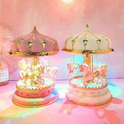 Deux boîtes à musique carrousel. La première est rose, la seconde blanc crème. Toutes deux ont des chevaux et des lumières LE