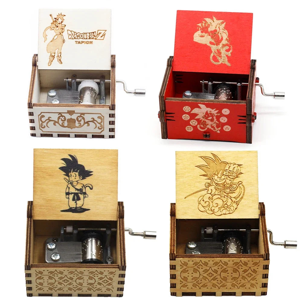 Quatre boîtes à musique Dragon Ball Z ouvertes, en bois clair et rouge, avec manivelle latérale et motifs gravés.