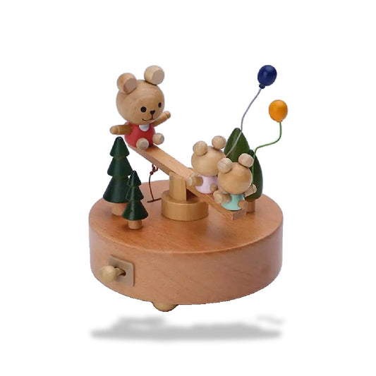 Boîte à musique en hêtre, avec trois oursons sur une balançoire et des arbres, des ballons décoratifs.