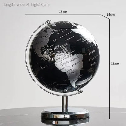 Globe terrestre décoratif noir et argenté en plastique, affichant les continents et les océans sur un support métallique rota