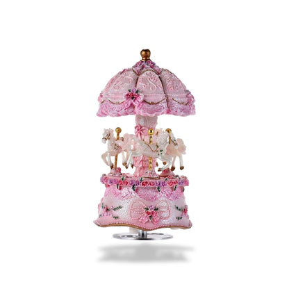 Boîte à musique carrousel rose de 16 cm de hauteur avec trois chevaux blancs, décorée de LED et de fleurs.