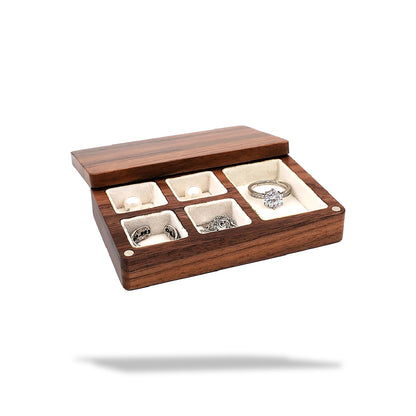 Boîte à bijoux rectangulaire en bois foncé, ouverte, avec six compartiments tapissés de tissu clair.