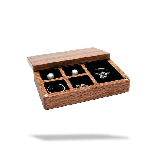Boîte à bijoux rectangulaire en bois ouverte, doublée de noir, avec cinq compartiments et un anneau.