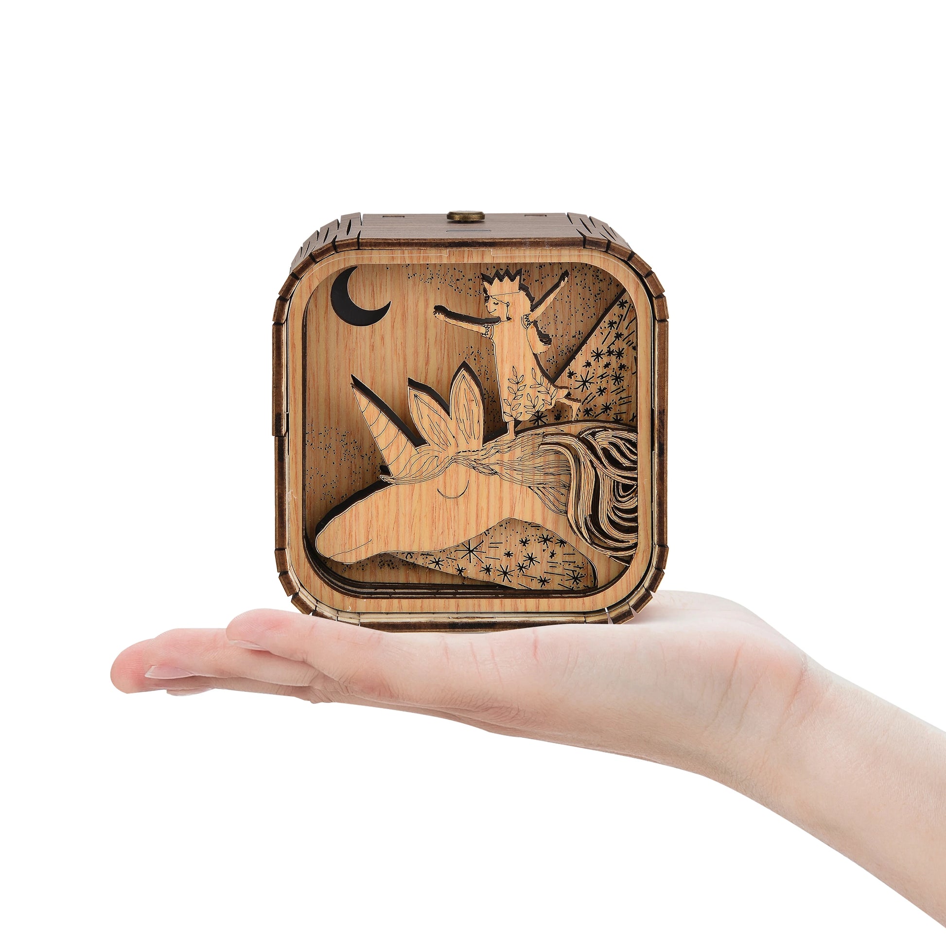 Boîte à musique veilleuse faite main en bois clair, avec une illustration de licorne et d'une fée avec des étoiles.