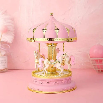 Boîte à musique carrousel rose avec des chevaux blancs. Fabriquée en résine, peinte à la main et lumineuse.