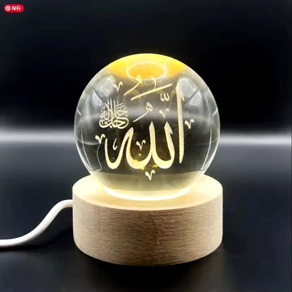 Veilleuse LED avec sphère en verre transparent sur socle en bois, illuminant une calligraphie arabe en 3D.