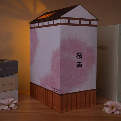 Kit de serre-livres en forme de maison japonaise traditionnelle, avec murs roses et base en bois.