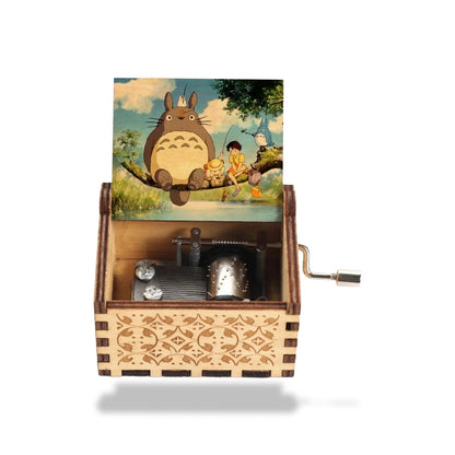 Boîte à musique en bois clair avec mécanisme apparent et manivelle. L'image Totoro décore le couvercle.