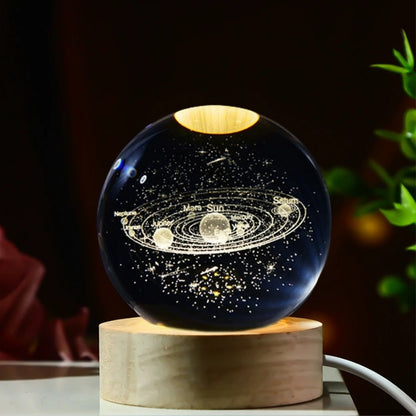 Veilleuse LED avec une sphère en verre affichant le système solaire illuminé, posée sur une base en bois.
